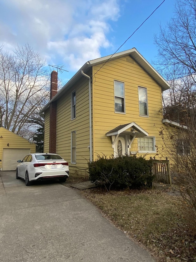 view of front of house with an outdoor structure and a chimney