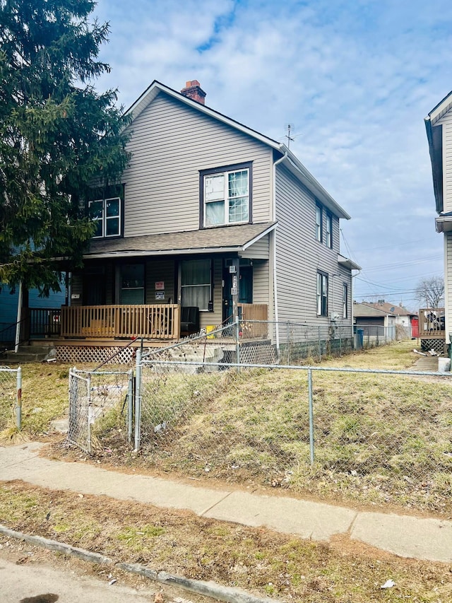 view of front of home with a fenced front yard, covered porch, and a chimney