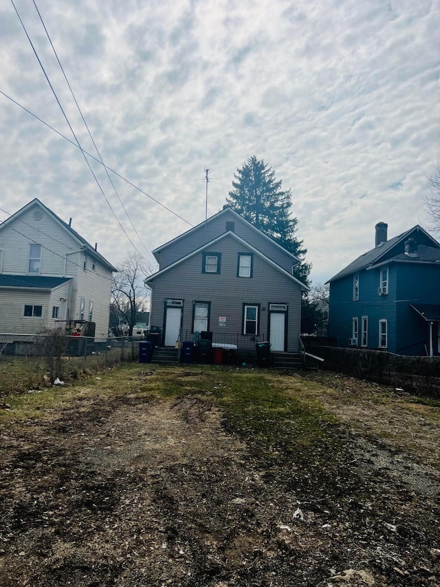 back of property featuring entry steps and fence
