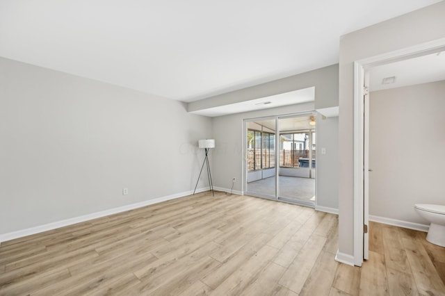 unfurnished room featuring baseboards and light wood-type flooring