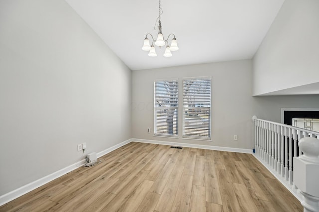 unfurnished dining area featuring visible vents, baseboards, an inviting chandelier, and light wood-style flooring