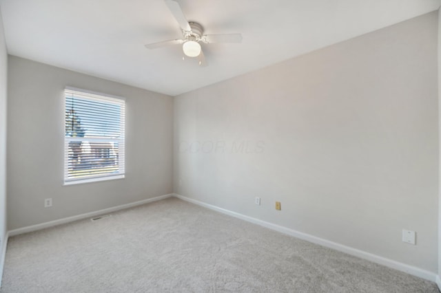 empty room with a ceiling fan, carpet, and baseboards