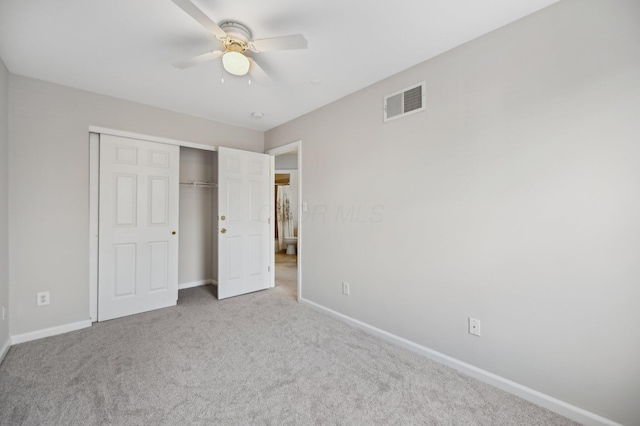 unfurnished bedroom with a closet, carpet flooring, visible vents, and baseboards