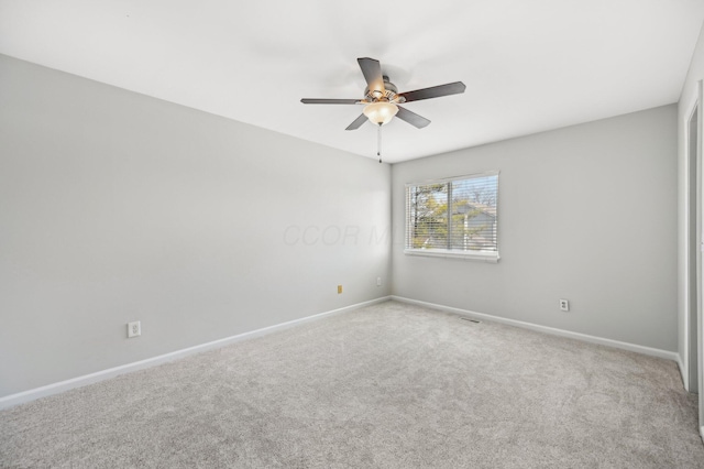 empty room featuring carpet, baseboards, and ceiling fan