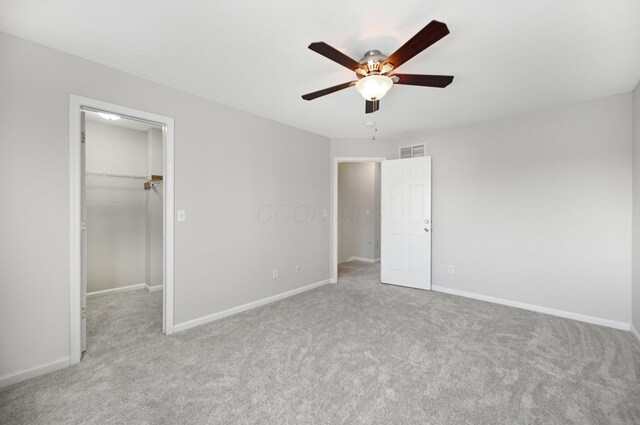 unfurnished bedroom with visible vents, baseboards, carpet, and a spacious closet