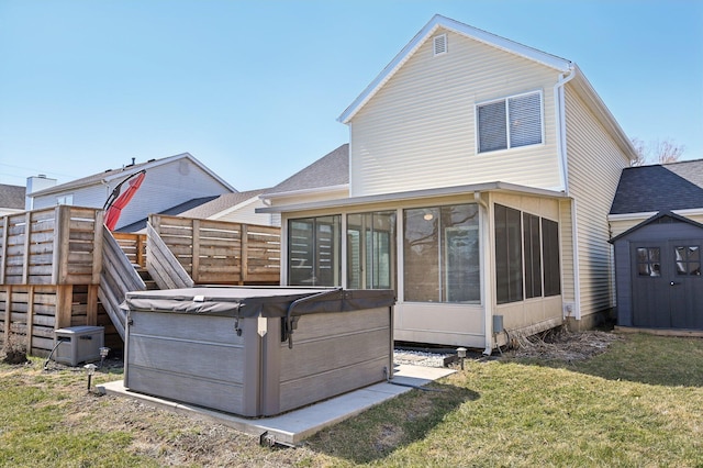 back of house with a wooden deck, a yard, a sunroom, an outbuilding, and a storage unit