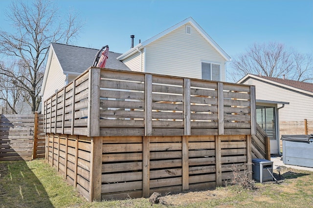 rear view of house featuring fence private yard and a shingled roof