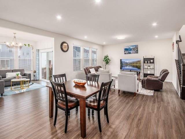 dining space with a healthy amount of sunlight, a notable chandelier, dark wood-type flooring, and recessed lighting