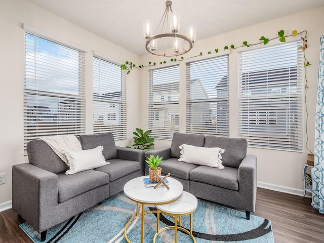 living room with baseboards, an inviting chandelier, and wood finished floors