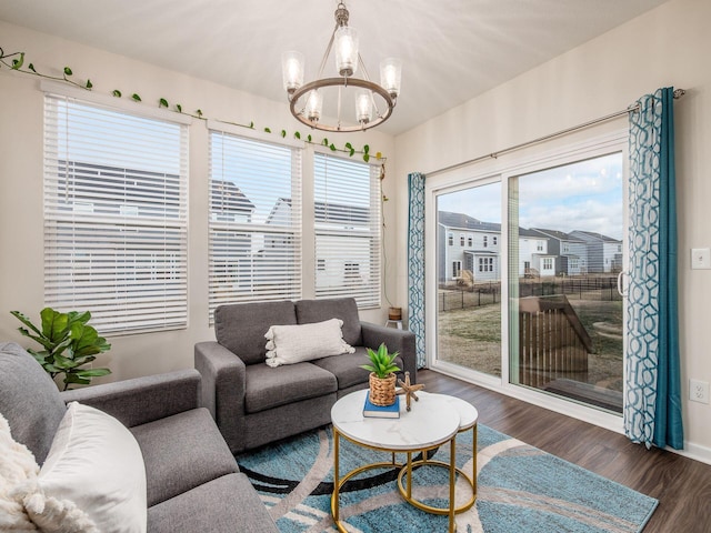 living area featuring a notable chandelier, baseboards, and wood finished floors