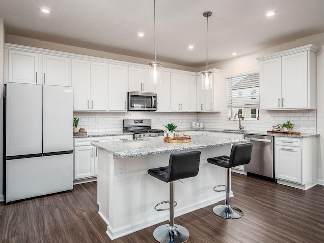 kitchen featuring appliances with stainless steel finishes, a sink, and white cabinetry