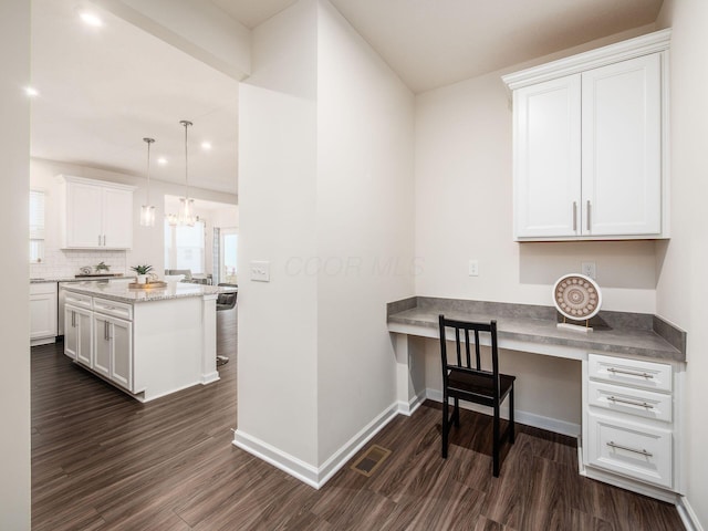 office space with dark wood-type flooring, built in study area, visible vents, and baseboards