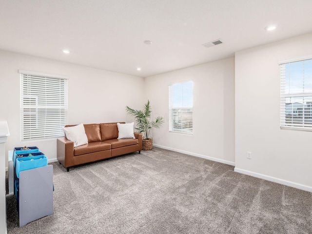 carpeted living room featuring recessed lighting, a healthy amount of sunlight, visible vents, and baseboards