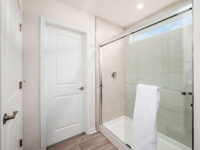 bathroom featuring a shower stall and wood finished floors