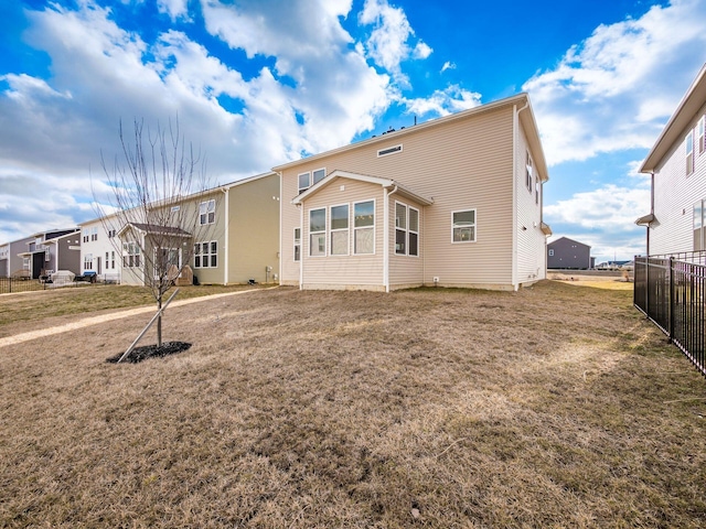 rear view of house with a yard, a residential view, and fence