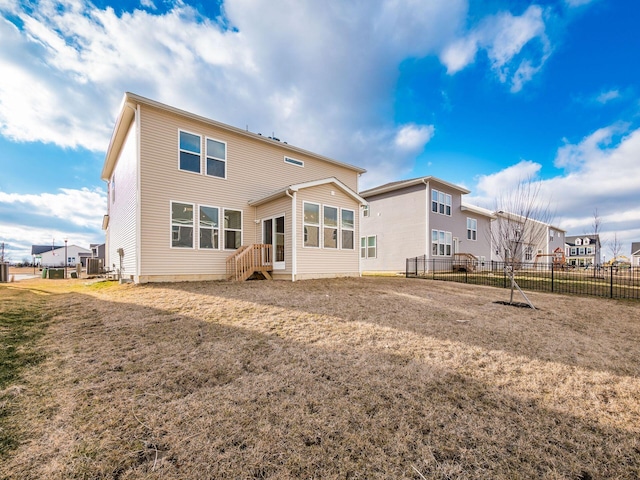 back of property with fence and a lawn