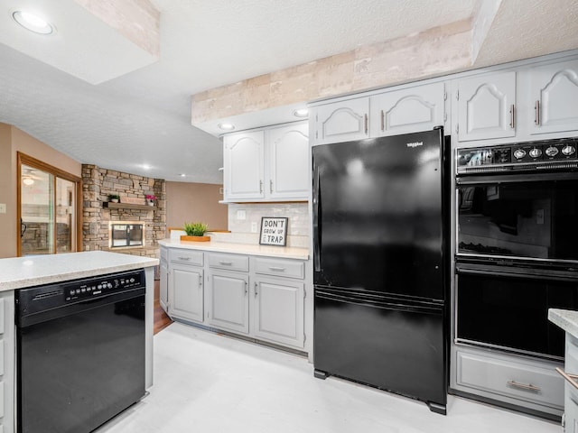 kitchen featuring tasteful backsplash, light countertops, a textured ceiling, black appliances, and white cabinetry