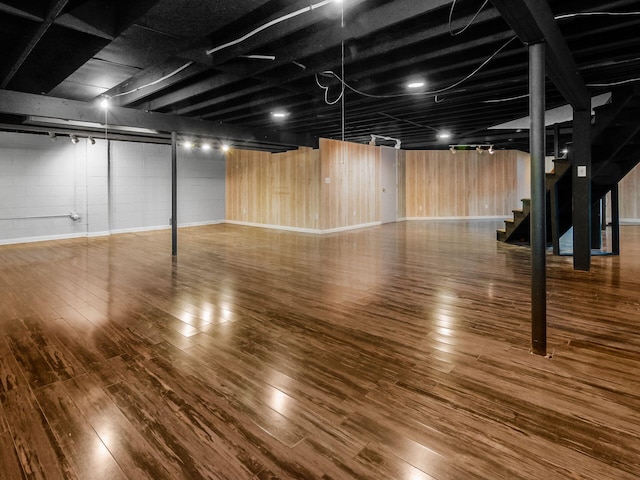 finished below grade area featuring stairway and hardwood / wood-style flooring