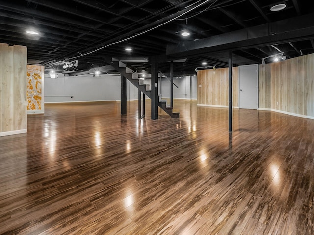 finished basement with stairway, wood finished floors, and baseboards