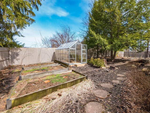 view of yard featuring a fenced backyard, a vegetable garden, an outdoor structure, and an exterior structure