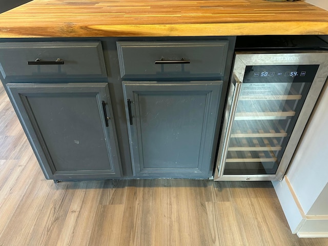 room details featuring beverage cooler, gray cabinetry, and wood finished floors