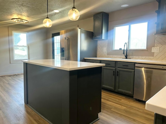 kitchen featuring tasteful backsplash, light wood-style flooring, appliances with stainless steel finishes, and light countertops