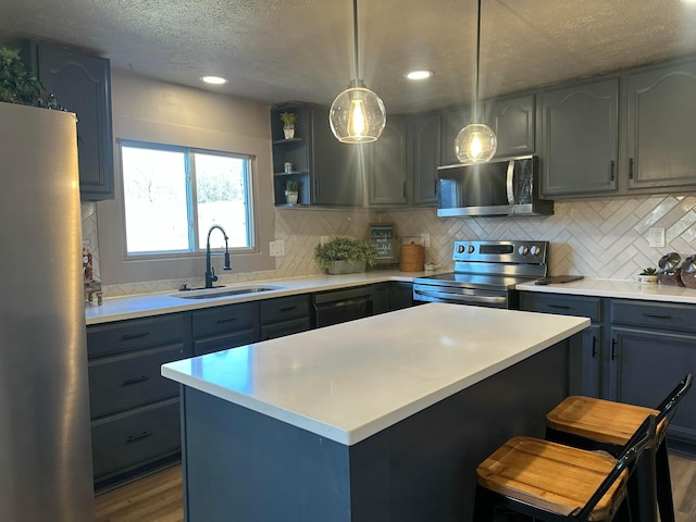 kitchen with stainless steel appliances, light countertops, and a sink