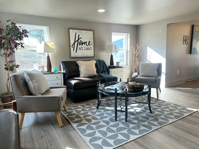 living area with a wealth of natural light, recessed lighting, baseboards, and wood finished floors