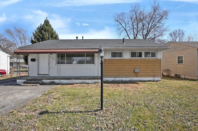 view of front of property with a front yard and roof with shingles