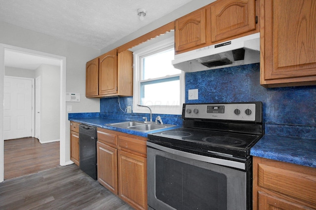 kitchen featuring dark countertops, under cabinet range hood, stainless steel electric stove, dishwasher, and a sink