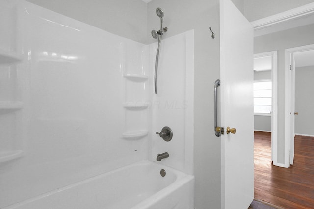 full bath with shower / bathing tub combination, baseboards, and wood finished floors