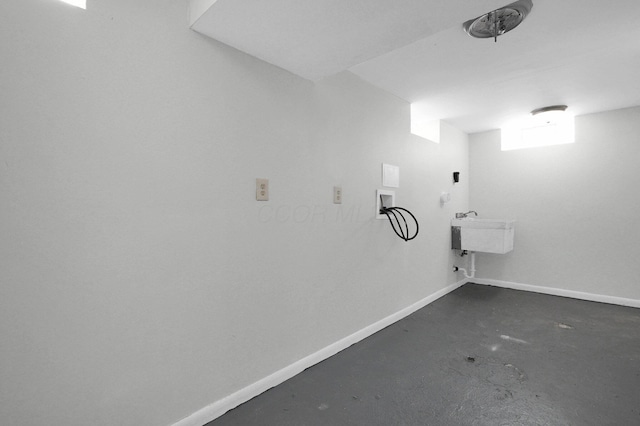 interior space featuring a sink, hookup for a washing machine, baseboards, and laundry area