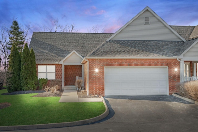 view of front of home with brick siding, an attached garage, a shingled roof, and aphalt driveway