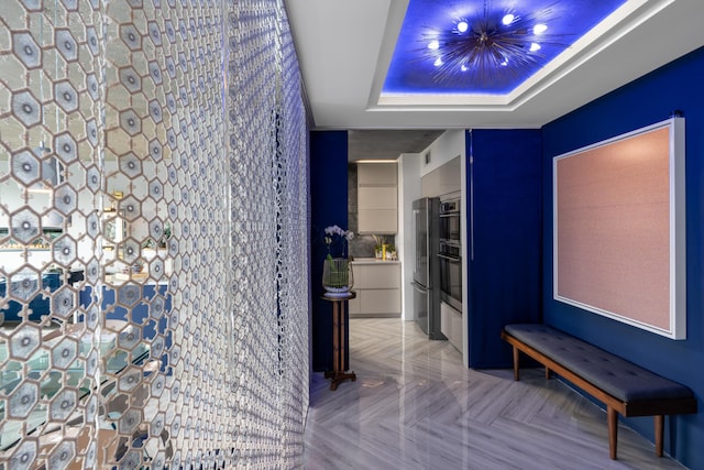 bathroom featuring a tray ceiling and an inviting chandelier