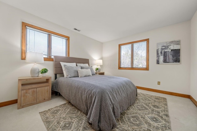 bedroom with light carpet, multiple windows, visible vents, and baseboards