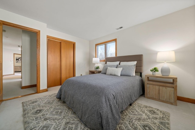 bedroom featuring a closet, visible vents, light carpet, and baseboards