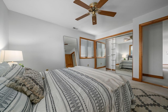 carpeted bedroom with visible vents, a closet, baseboards, and a ceiling fan