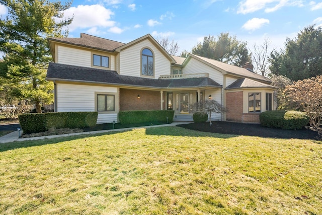 traditional-style house with brick siding, a chimney, and a front lawn