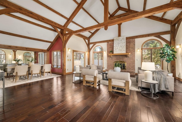 living area featuring lofted ceiling with beams, hardwood / wood-style floors, and a fireplace