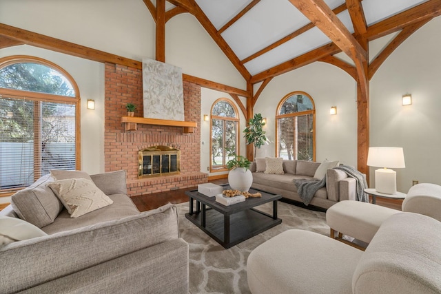 living area with high vaulted ceiling, a brick fireplace, wood finished floors, and beam ceiling