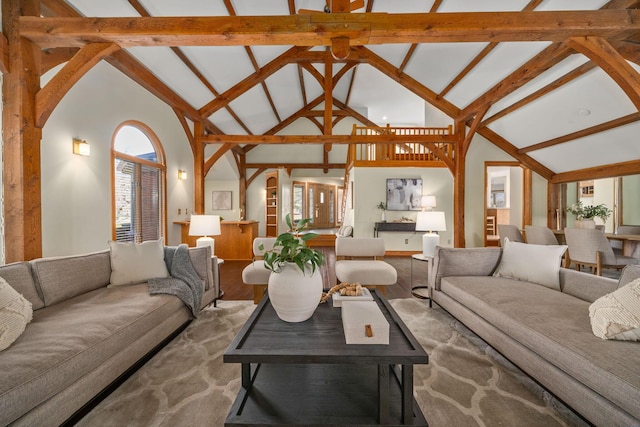 living area with high vaulted ceiling, beamed ceiling, and wood finished floors