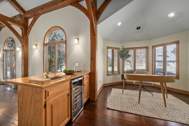 kitchen featuring beverage cooler, a sink, baseboards, beamed ceiling, and dark wood finished floors