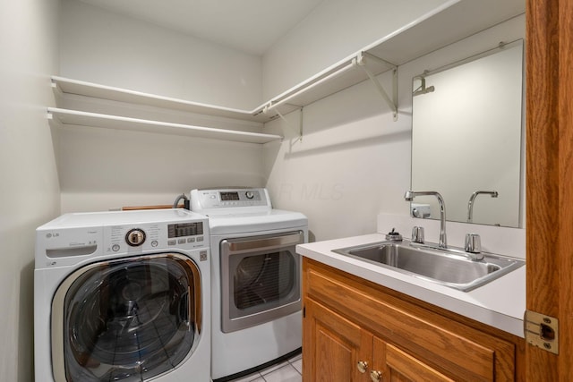 laundry room with light tile patterned floors, cabinet space, a sink, and separate washer and dryer