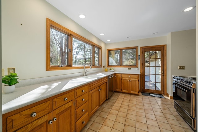 kitchen with electric range, a sink, light countertops, brown cabinets, and dishwasher