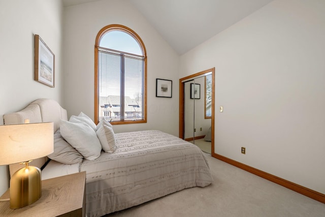 carpeted bedroom with lofted ceiling and baseboards