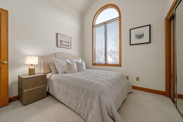 carpeted bedroom featuring a closet, vaulted ceiling, and baseboards