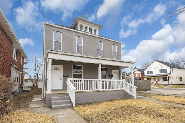 traditional style home with a porch and stucco siding