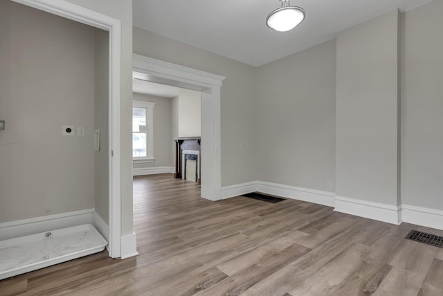 interior space with visible vents, a fireplace, baseboards, and wood finished floors