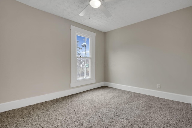 carpeted spare room with a textured ceiling, ceiling fan, and baseboards