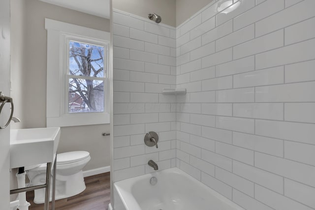 full bath featuring  shower combination, baseboards, toilet, and wood finished floors